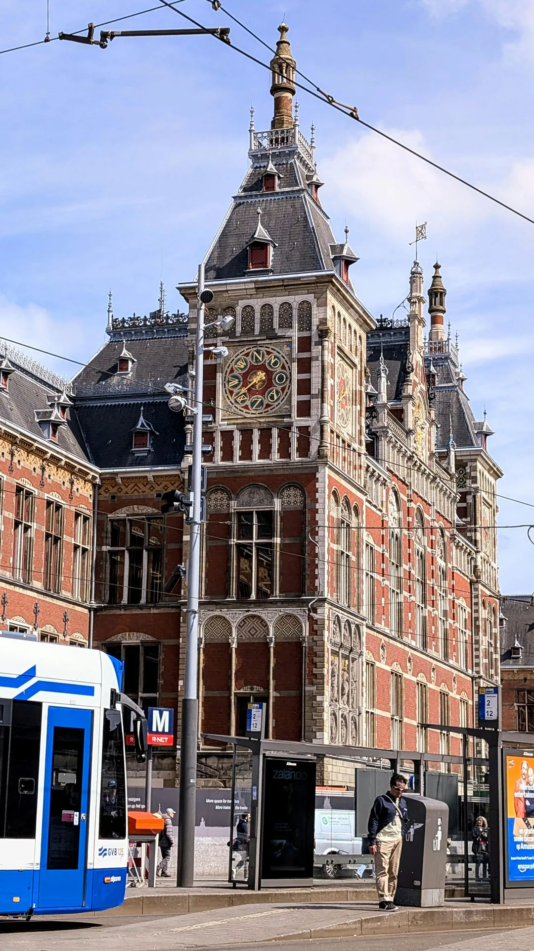 A blue GVB tram in front of Amsterdam Central Station