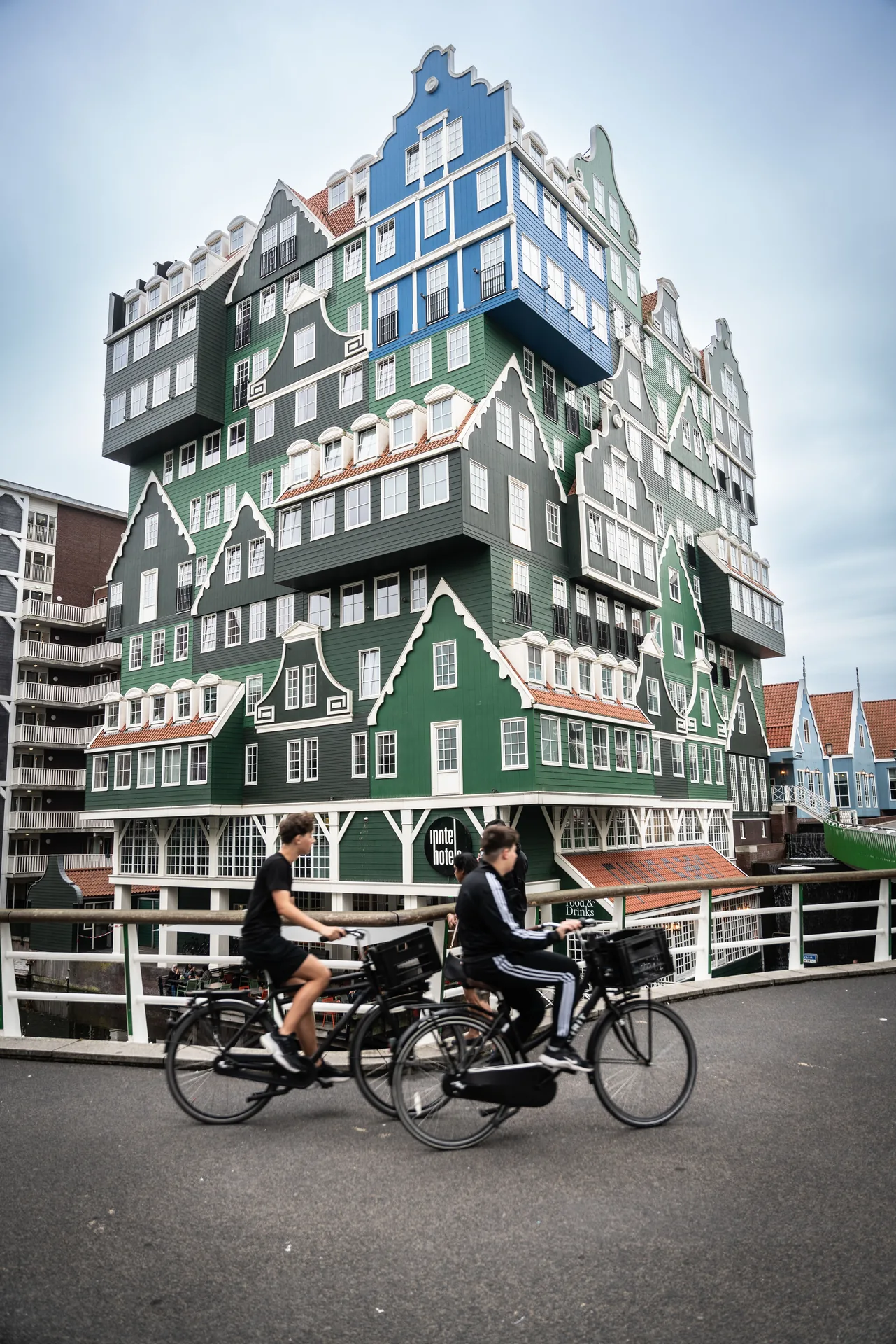Cyclists passing the Inntel Hotel in Zaandam, built from stacked traditional Zaan houses